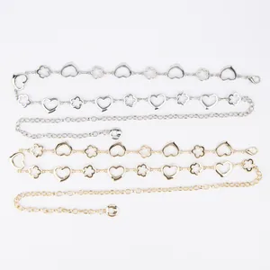 Detailed view of silver and gold metal waist chains with heart and clover links