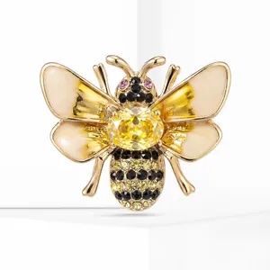 Macro detail view of a gold-tone bee brooch featuring yellow rhinestones and enamel wings.