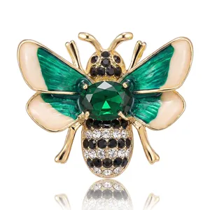 Elegant gold bee brooch featuring green enamel and sparkling crystal rhinestones.