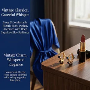 Detailed shot of vintage gold huggie hoops with sapphire blue stones on a vanity table