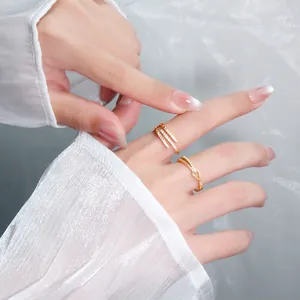 Detailed shot of elegant gold geometric and knot rings with pave crystals on model