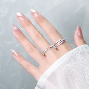 Detailed macro view of silver geometric open rings with sparkling pavé crystals