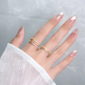 Close-up of gold geometric open rings with sparkling crystals on a female hand