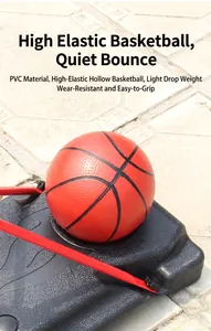 Detail shot of a red high-elasticity PVC basketball resting on a black base outdoors.