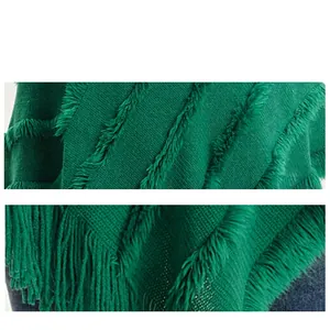 Soft green knit faux cashmere poncho featuring elegant braided tassels and cozy texture