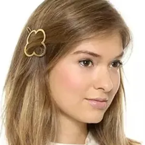 Vue détaillée d'une pince à cheveux dorée en forme de trèfle à quatre feuilles