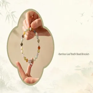 Detail view of colorful beaded bracelet with a silver bamboo leaf charm.