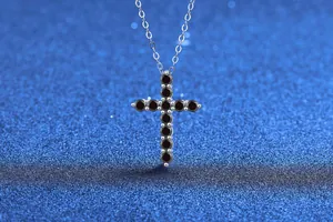 Close-up detail of s925 sterling silver necklace with black moissanite cross pendant
