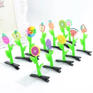 Detailed view of colorful children's hair clips with cute fruit and flower designs.
