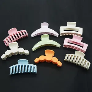Detailed view of colorful plastic hair claw clips in various pastel shapes and sizes
