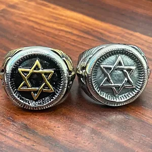 Detailed macro shot of vintage stainless steel Star of David signet rings on wood.