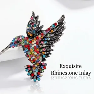 Close-up of colorful rhinestone-encrusted hummingbird brooch with vintage alloy finish