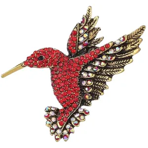 Vintage hummingbird brooch encrusted with red and iridescent rhinestones on gold alloy