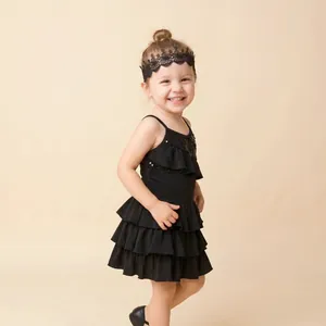 Detail shot of a young girl wearing a black hollow lace headband with embroidered flowers