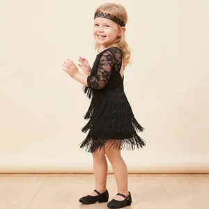Detailed view of child model wearing black lace fringe Latin dance dress and headband
