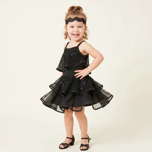 Close-up of a smiling child wearing a black lace headband for Latin dance performance.