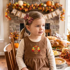 Detailed view of a little girl wearing an embroidered Thanksgiving bow hair clip