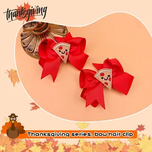 Close-up of red ribbon bow hair clips with cute pizza embroidery for Thanksgiving.