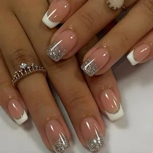 Close-up detail of elegant French tip press-on nails with silver glitter gradient