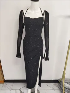 Robe noire à manches longues en maille avec fente haute et paillettes sur mannequin