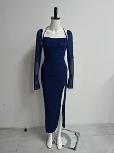 Détail de la robe pailletée bleu marine avec fente haute et manches longues mesh