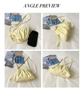 Detailed angle preview of a chic pleated yellow polka dot dumpling bag on white bedding.