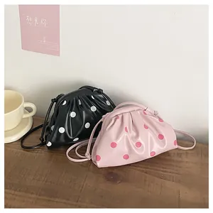 Close-up of stylish polka dot pleated dumpling bags in black and pink colors.