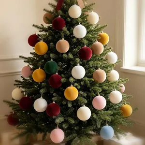Elegant colorful flocked velvet Christmas ball ornaments hanging on a decorated pine tree