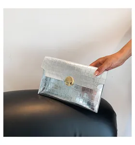 Close-up of elegant silver metallic envelope clutch bag with stone pattern detail