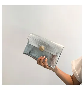 Detailed view of silver stone-textured envelope clutch with round metallic clasp