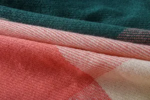 Macro detail showing the soft texture and plaid pattern of cashmere-like shawl fabric