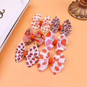 Gros plan de barrettes à nœuds imprimés pour enfants avec motifs festifs sur fond orange.
