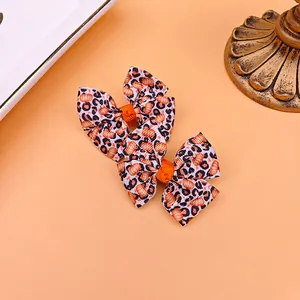 Gros plan de jolies barrettes à nœud avec motif léopard et citrouille pour filles