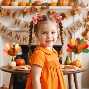 Gros plan d'une fillette portant des nœuds de cheveux orange pour Thanksgiving