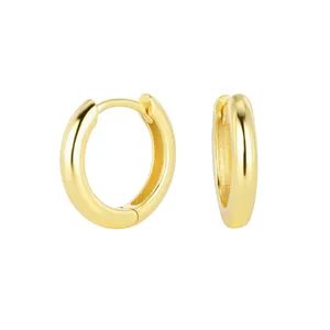 Macro detail of polished gold-plated S925 sterling silver small huggie hoop earrings