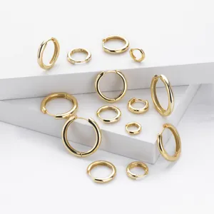 Detailed view of various sizes of S925 sterling silver gold plated huggie hoop earrings.