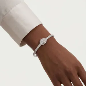Elegant silver zircon bangle featuring a shell motif design worn for a modern fashion look