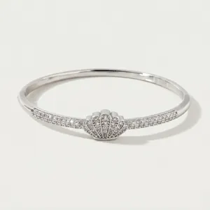 Elegant silver shell bangle bracelet with pavé-set zircons on a white background