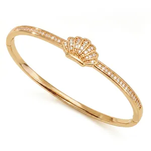 Elegant gold seashell bangle bracelet with pavé-set cubic zirconia stones