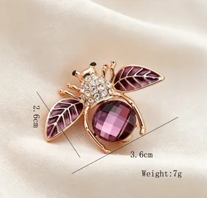 Vue rapprochée d'une broche abeille violette avec strass en cristal et détails émail.