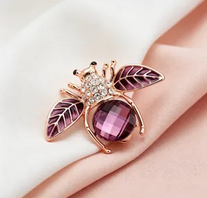 Vue détaillée d'une jolie broche abeille avec cristal violet et strass étincelants