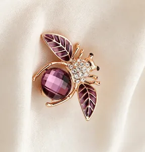 Vue macro détaillée d'une broche abeille violette étincelante avec cristal et émail