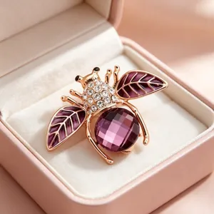 Exquisite rose gold bee brooch featuring purple crystal and faceted stone in gift box