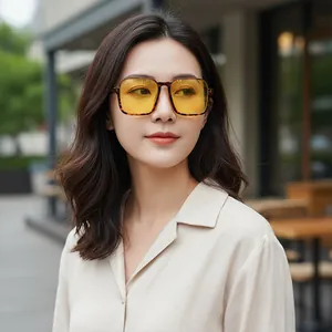 Stylish square tortoiseshell sunglasses with yellow lenses worn by a model outdoors