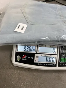 Weight demonstration of men's light blue denim overalls showing 936.6g on a scale