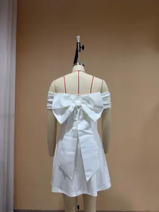 Detailed back view of a white off-shoulder mini dress featuring a large decorative bow