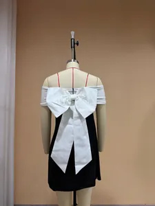 Detailed back view of an off-the-shoulder black mini dress featuring a large white bow