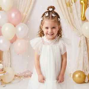 Petite fille portant des barrettes en perles blanches et strass en forme de cœur.