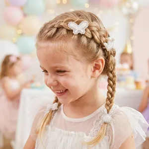 Gros plan d'élastiques à cheveux en perles et strass sur les tresses d'une petite fille