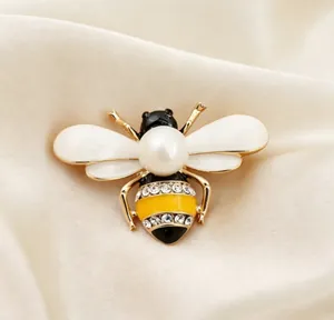Close-up of a cute pearl bee brooch with sparkling rhinestones and white enamel wings
